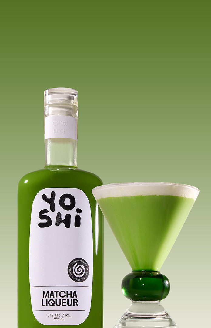 Bottle of Yoshi Matcha Liqueur with a filled martini glass on a green background